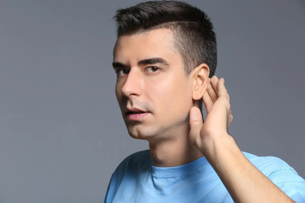 Man holding his hand to his ear